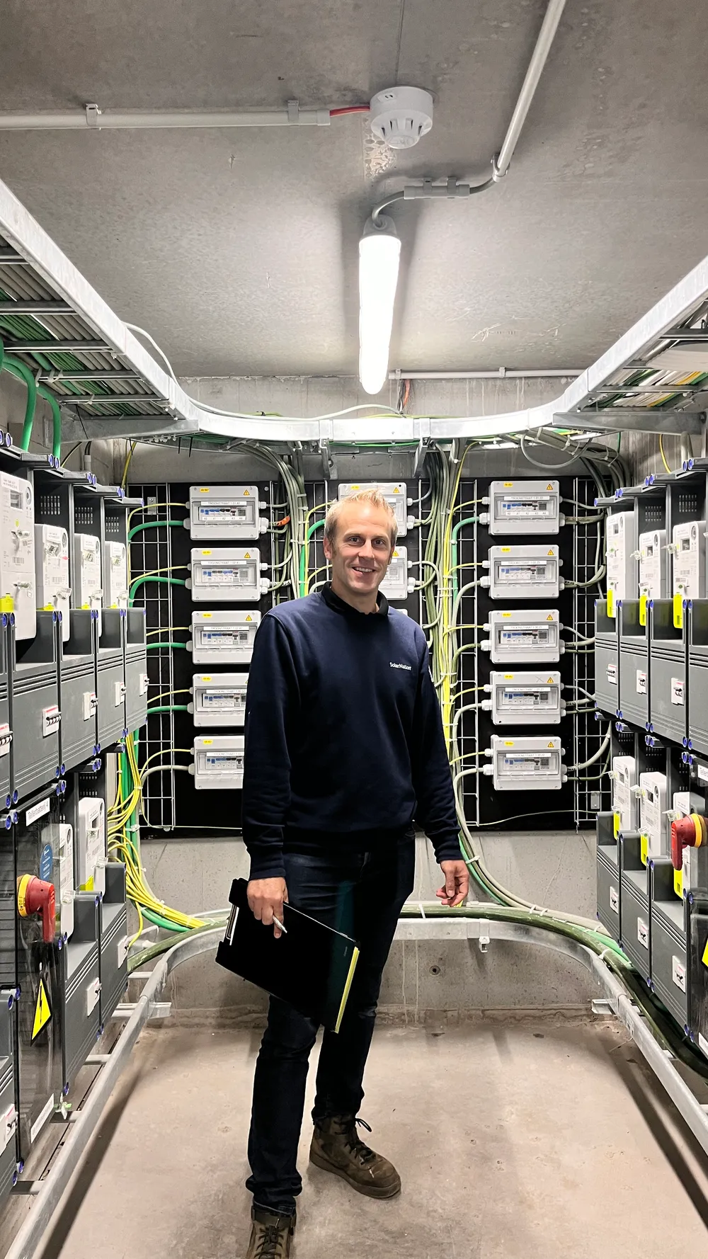 Tom, ingenieur bij Solarnation, bij een AREI-gekeurde elektrische verdeelkast
