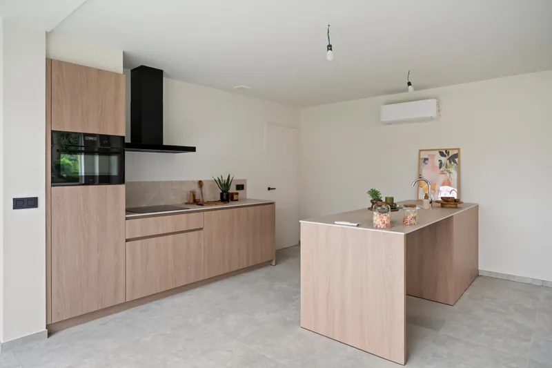 Keuken met wandunit van de lucht-luchtwarmtepomp rechts tegen de muur, woning in Torhout