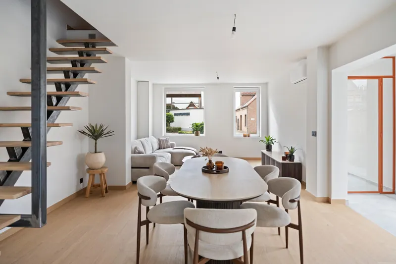 Leefruimte met eettafel, zithoek en binnenunit van het multisplit-systeem in de woning in Torhout