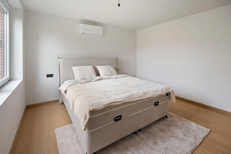 Slaapkamer met wandunit van de multisplit lucht-luchtwarmtepomp in de woning in Torhout