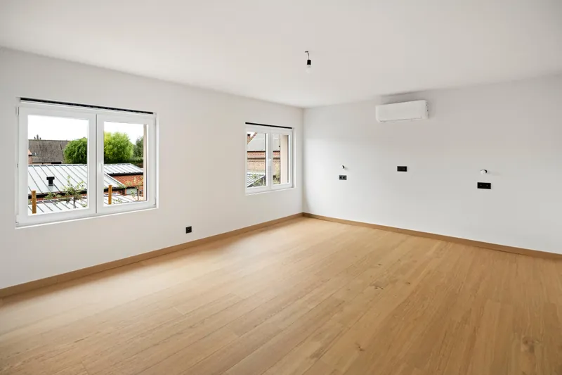 Binnenunit van de lucht-luchtwarmtepomp aan de wand van een afgewerkte kamer op de verdieping in Torhout