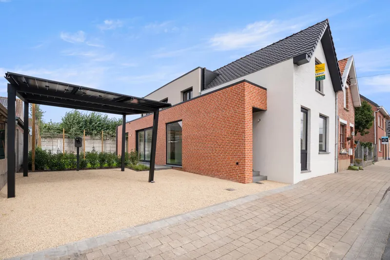 Solar carport naast de gerenoveerde woning in de Revinzestraat in Torhout, gezien vanaf de straat