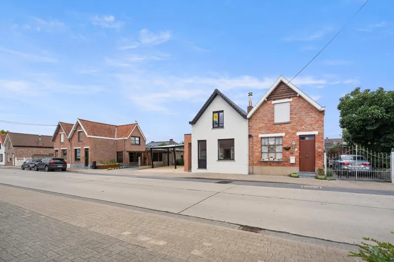 Straatbeeld van de Revinzestraat in Torhout met de gerenoveerde woning en de solar carport