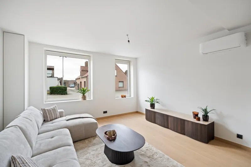 Zithoek met wandunit van de lucht-luchtwarmtepomp die zowel verwarmt als koelt, woning Torhout